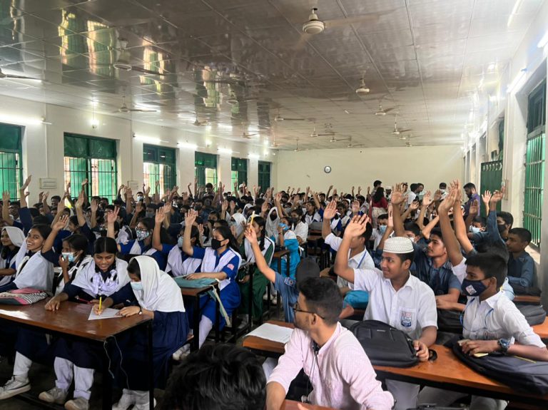 students raising hands to answer question in a program